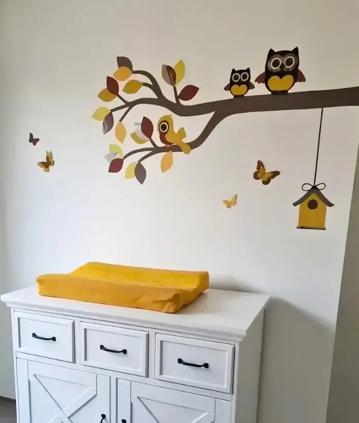 Okergele babykamer met sierlijke uilentak behangsticker